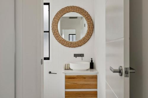 a bathroom with a sink and a mirror at Holiday Haven on Spoonbill Pet Friendly with Pool in Kingscliff