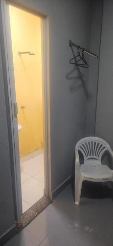 a bathroom with a mirror and a chair in a room at Boa opção in Manaus