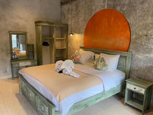 ein Schlafzimmer mit einem Bett mit zwei Stofftieren darauf in der Unterkunft Tendan Residence Hotel in Legian