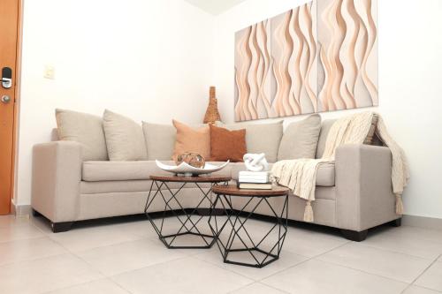 サンティアゴ・デ・ロス・カバリェロスにあるRustic Charm, Apartment in the heart of Santiagoのソファとテーブル2つがあるリビングルーム