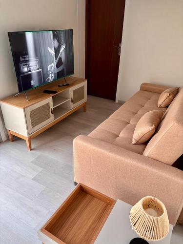 a living room with a couch and a flat screen tv at Tres de Mayo in San Luis