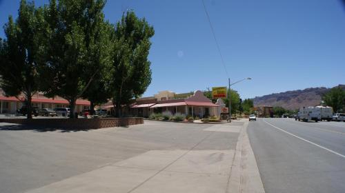 an empty street in a town with trees and buildings at Adventure Inn Moab in Moab