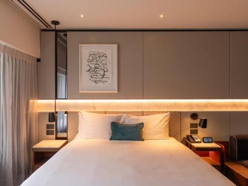 a bedroom with a large bed with a light above it at Crowne Plaza Auckland by IHG in Auckland