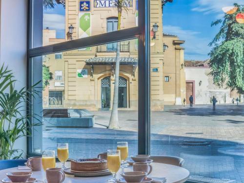 マラガにあるノボテル スイート マラガ セントロのケーキとオレンジジュースのグラスを用意したテーブル