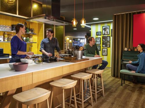 a group of people sitting at a kitchen counter at Aparthotel Adagio Paris Bercy Village in Paris