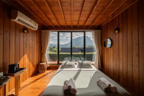 una cama grande en una habitación con una ventana grande en The CAMPIAN, en Chiang Mai