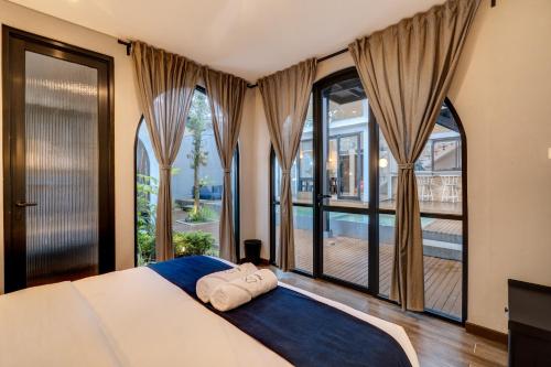 een slaapkamer met een groot bed en grote ramen bij Momo Villa Bandung in Bandung