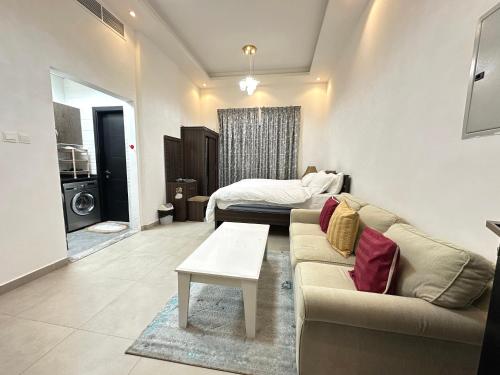a living room with a couch and a bed at Entire Studio Apartment Beside Oasis towers in Ajman