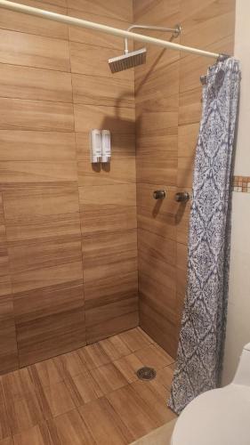 a shower with a shower curtain in a bathroom at Fick's house in Oaxtepec