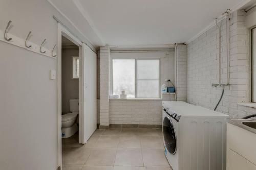 eine Waschmaschine im Bad mit Fenster in der Unterkunft 64 Bathurst Street in Elliott Heads