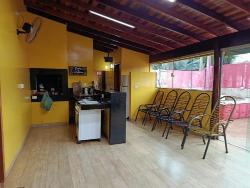 una camera con sedie e una cucina con pareti gialle di Rancho Aconchego para seu lazer a Panorama
