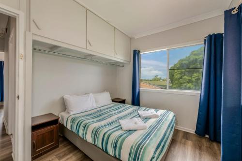 ein kleines Schlafzimmer mit einem Bett und einem Fenster in der Unterkunft 64 Bathurst Street in Elliott Heads