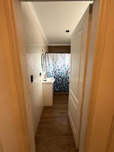 een gang met een badkamer met wastafel en spiegel bij Dpto lo de Bruno in Santa Clara del Mar