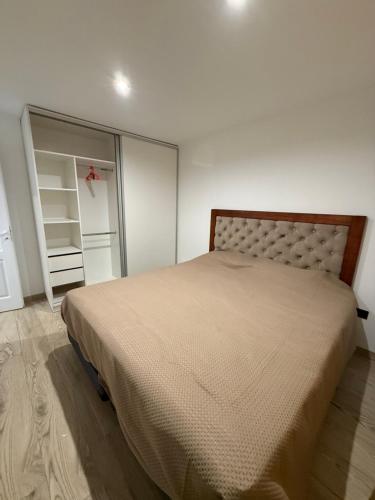 een slaapkamer met een bed en een grote spiegel bij Dpto lo de Bruno in Santa Clara del Mar