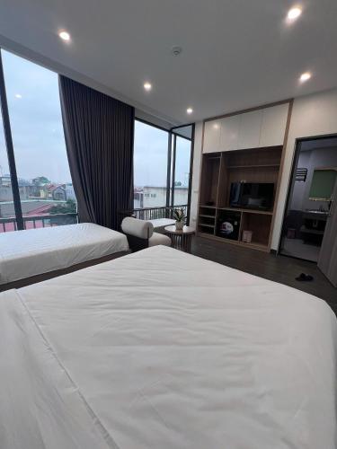 a bedroom with two beds and a large window at Hiden An Hotel in Ninh Binh