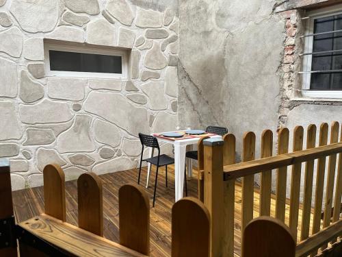 een houten terras met een tafel en stoelen naast een gebouw bij Le Montagnard, Studio cosy, centre de Montbrison in Montbrison