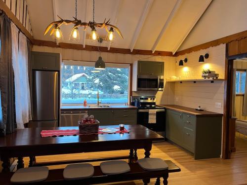 uma cozinha com uma mesa e uma grande janela em Chalets Village Suisse de Val-David em Val-David