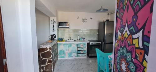 una cucina con un dipinto colorato sul muro di La Morada a Gaiman