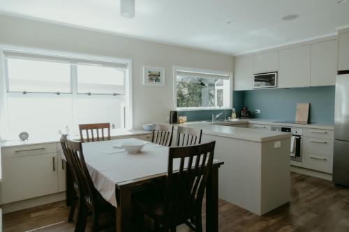 a kitchen with a table and chairs and a kitchen with white cabinets at Sweet on Sutton in Richmond
