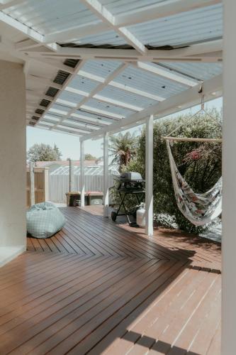a wooden deck with a hammock on it at Sweet on Sutton in Richmond
