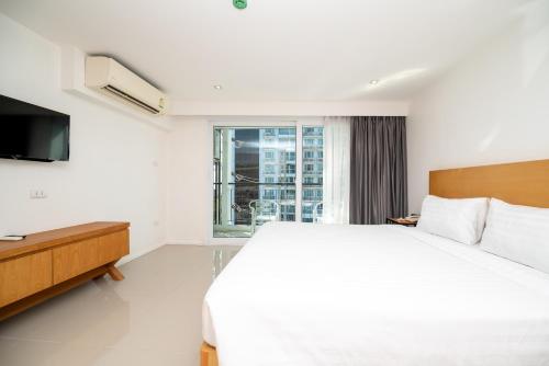 En eller flere senge i et værelse på Fourium Pattaya Hotel and Serviced Residence