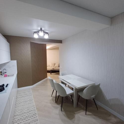 une cuisine et une salle à manger avec une table et des chaises dans l'établissement Apartament Buiucani Alba Iulia, à Chişinău