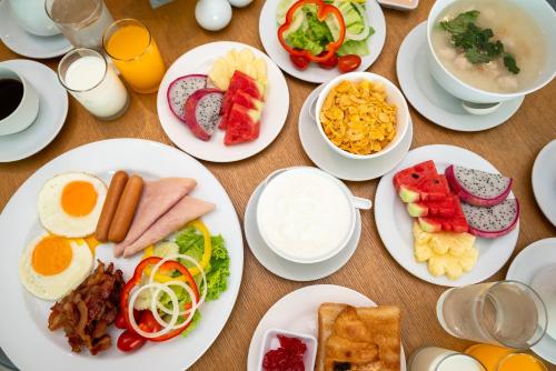 een tafel met borden ontbijtproducten erop bij Fourium Pattaya Hotel and Serviced Residence in Pattaya South