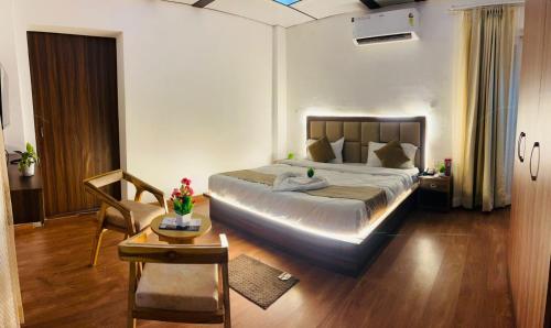 una camera da letto con un letto grande e un tavolo di Simran Aura Resort a Dehradun