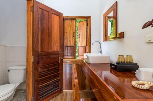 baño con encimera de madera con lavabo y aseo en Sabaidee Nam Ou River View, en Nongkhiaw