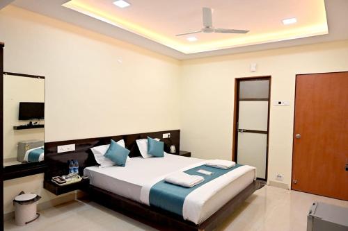 JāmbにあるHotel Sunriseの青い枕が付いた大きなベッドのある寝室