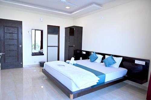 JāmbにあるHotel Sunriseの青い枕が付いた大きなベッドのある寝室