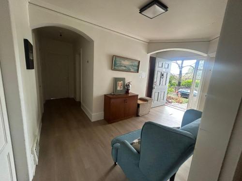 a living room with a blue chair and a door at Vancouver Guest House - Airport 10 Min - Free Parking & Fast Wi-Fi in Vancouver