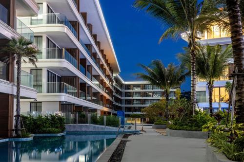 an apartment building with a swimming pool and palm trees at Kora 2br pool Apartment in Layan Beach