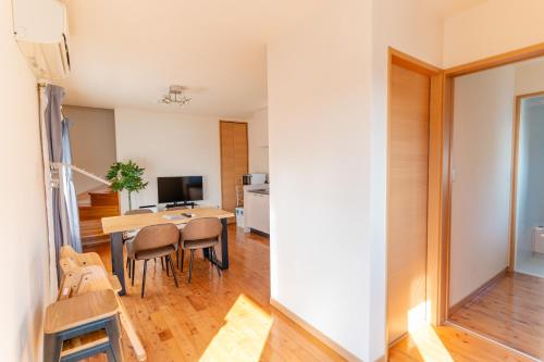 a living room with a dining room table and a kitchen at オーシャンフロント日南 絶景海ビュー 駐車場2台無料 Good Stay Apartment in Nichinan