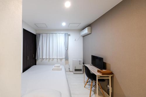 a bedroom with a bed and a desk with a computer at Niseko Hirafu Ski Resort Condo in Kutchan