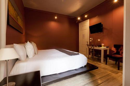 a bedroom with a white bed and a desk and a television at Hotel Villa Condesa in Mexico City