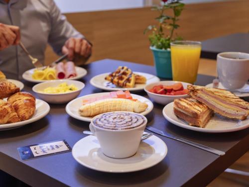 a table topped with plates of food and cups of coffee at ibis budget SP Centro Sao Joao in Sao Paulo