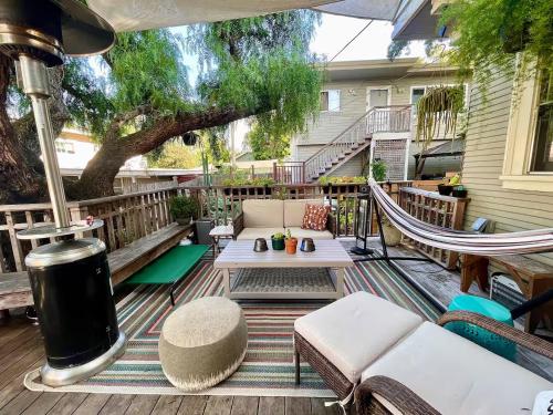 a patio with a couch and a hammock on a deck at Garden Suite- Private Deck, Hot Tub & Fast WiFi in Vallejo