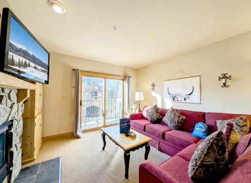 a living room with a red couch and a tv at Red Hawk Lodge 2297 by SummitCove Lodging in Keystone