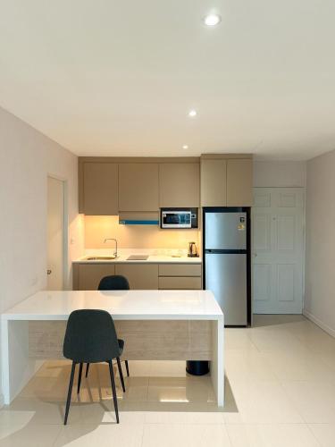 a kitchen with a white counter and a refrigerator at Avana Residence in Bangna