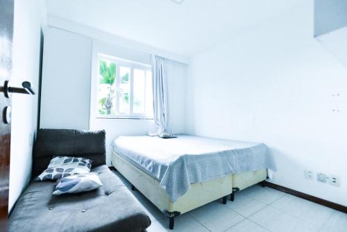a white bedroom with a bed and a couch at Tree Bies Resort - Refúgio a beira-mar in Entre Rios