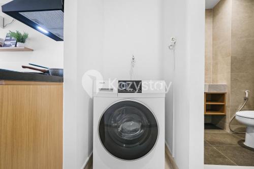 une machine à laver dans une salle de bain à côté des toilettes dans l'établissement Hesrin by Kozystay - Sentul, à Citaringgul 1