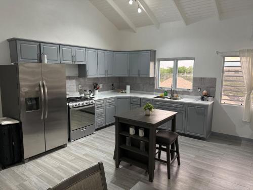 een keuken met roestvrijstalen apparaten en een tafel bij Serenity Retreat in Codrington Village