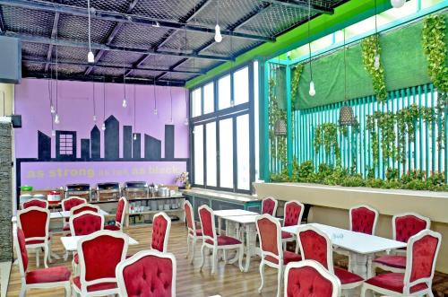 Alodia Powered by Archipelago في Tanjungkarang: غرفة انتظار مع طاولات وكراسي ونباتات