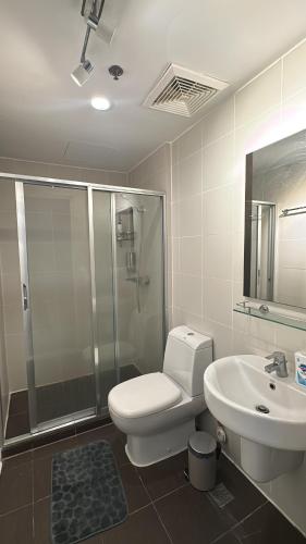 a bathroom with a toilet and a shower and a sink at KL Rooms at Greenbelt makati with cityview in Manila