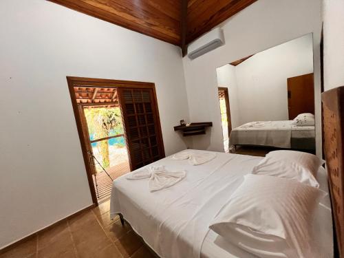 ein Schlafzimmer mit einem weißen Bett und einem Fenster in der Unterkunft Casa Do Mar in Ubatuba