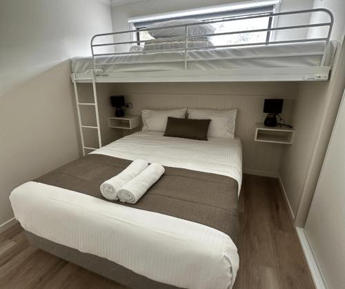 a bedroom with a bed with two bunk beds at BIG4 Apollo Bay Pisces Holiday Park in Apollo Bay