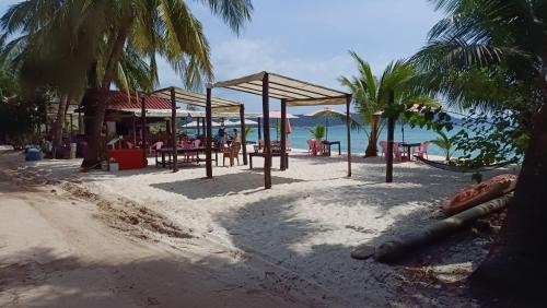 a playground on a beach with palm trees and the ocean at Paradiso Village Center Bungalows in Koh Rong Island