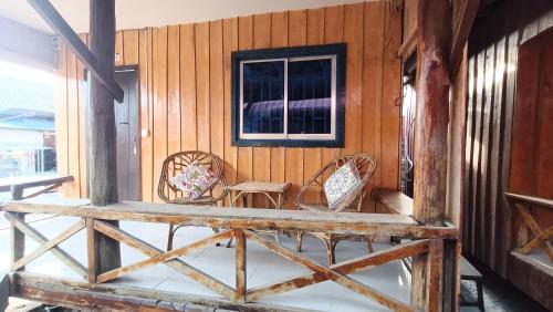 eine Veranda mit zwei Stühlen und einem Fenster in der Unterkunft Paradiso Village Center Bungalows in Koh Rong