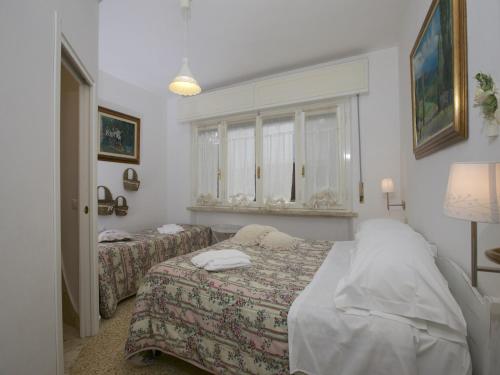 a bedroom with two beds and a window at Huge Holiday Home in Marina di Castagneto Carducci near Sea in Donoratico